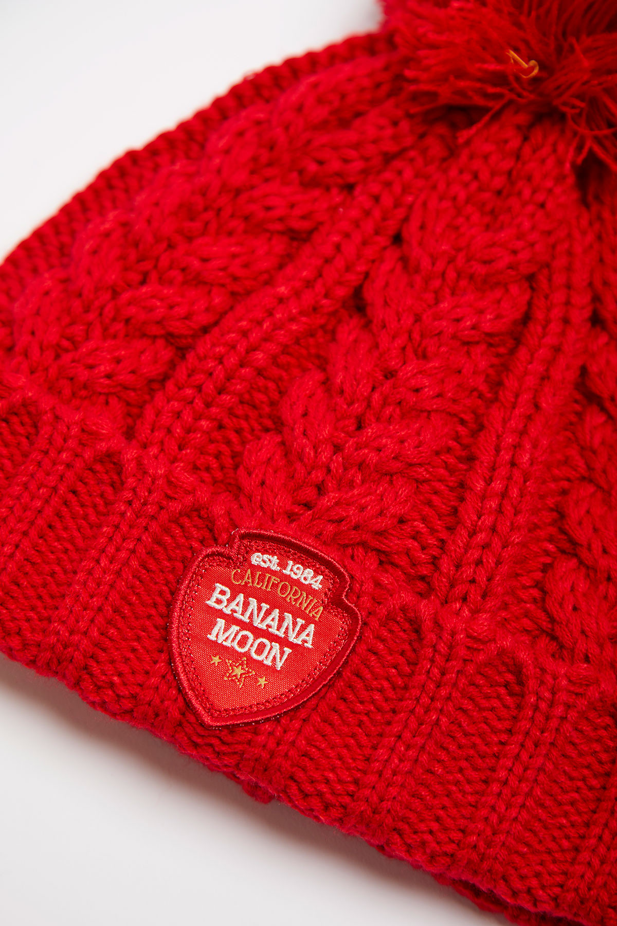 Berretto da donna rosso intrecciato con pon-pon |HOWSON LEMONWOOD | Banana  Moon | Banana Moon®